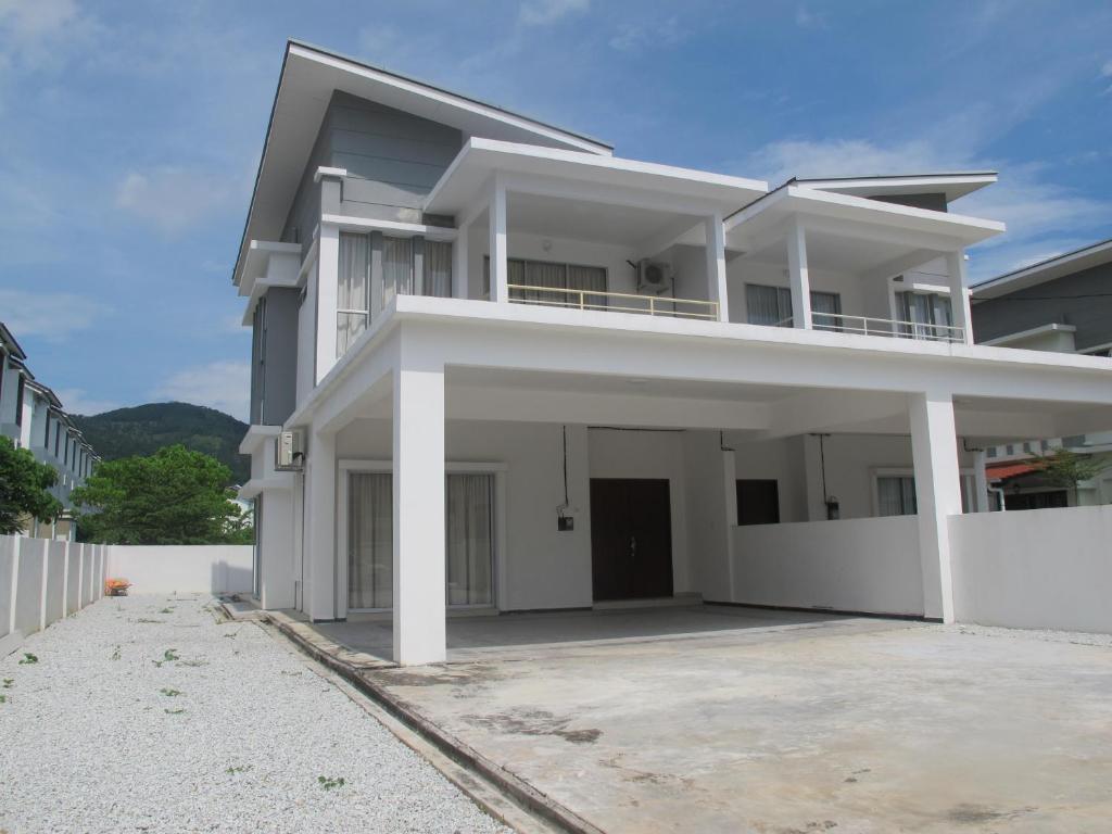 uma grande casa branca com uma entrada em Properties Homestay, Balik Pulau em Balik Pulau