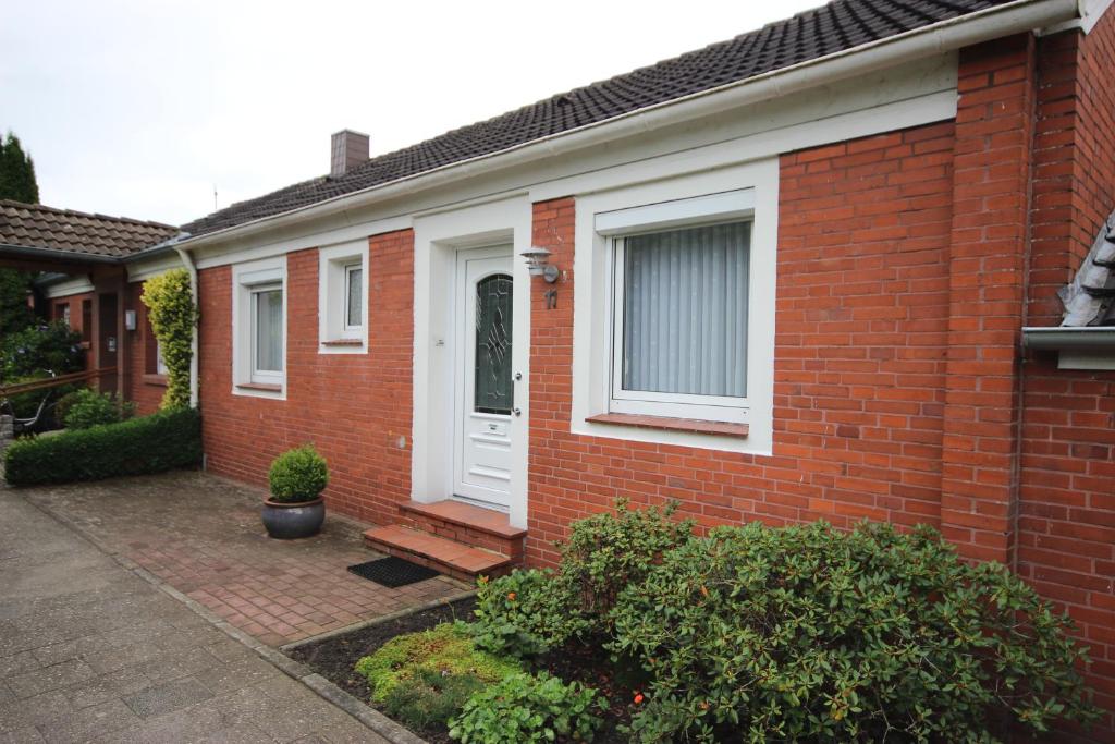 a red brick house with a white door at Ferienwohnung Leer in Leer