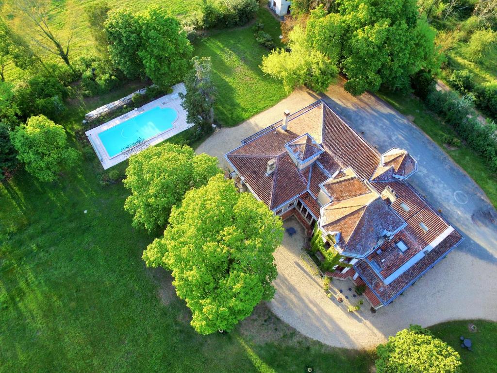 Cette chambre offre une vue sur une maison dotée d'une piscine. dans l'établissement Les Luz - Chambres d'hôtes, à Uzeste