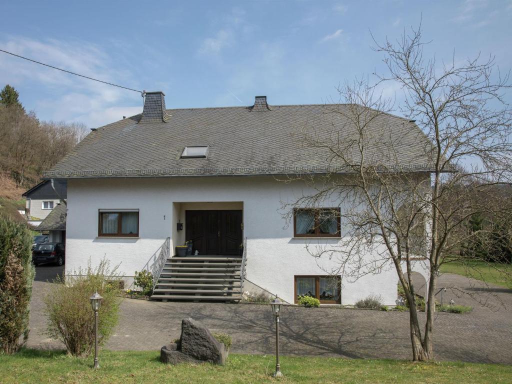 a white house with a porch and stairs at Lovely Mansion in Lirstal with Terrace in Lirstal