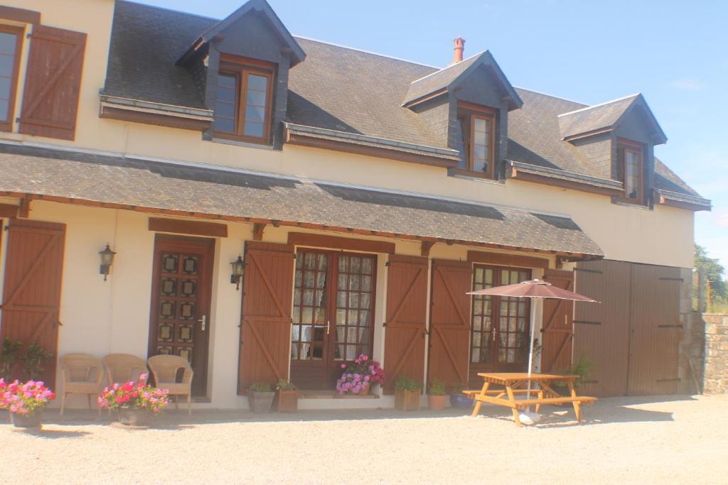 a building with a table and an umbrella at Walnut House in Vire