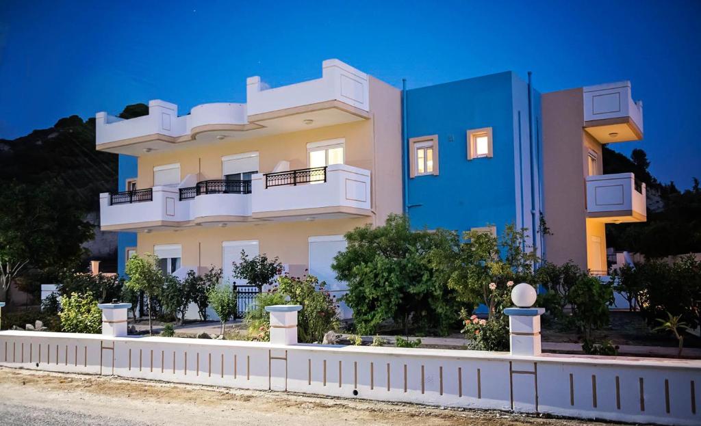 a building with a white fence in front of it at Nephele Apartments in Faliraki