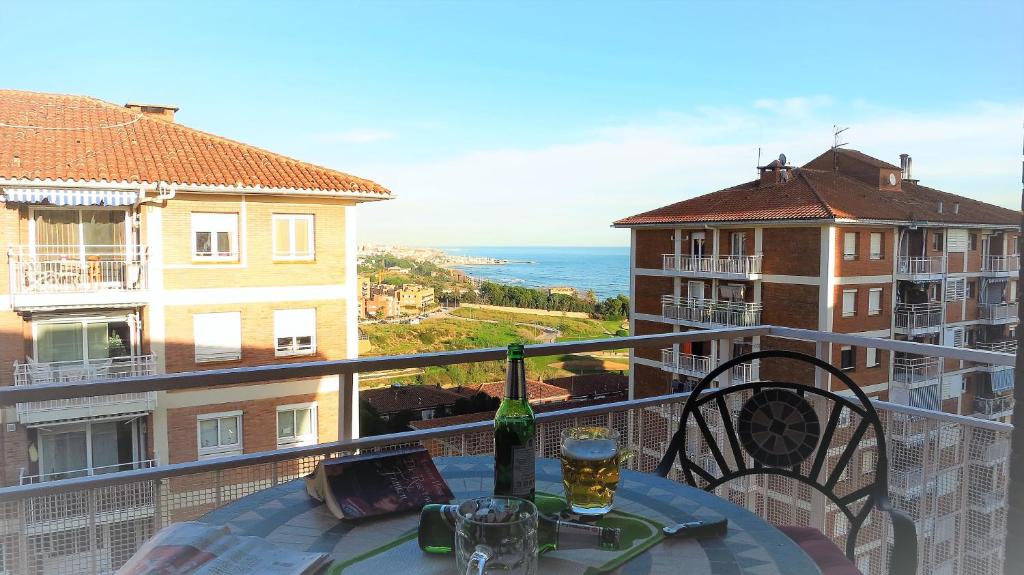 a table with a wine bottle and glasses on a balcony at Helena Seaview & Beach-apartment in Montgat
