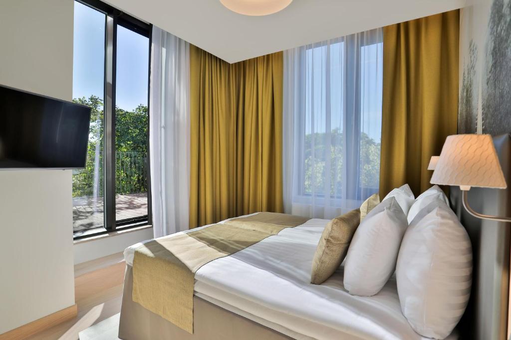 a hotel room with a bed with a large window at Centennial Nexus Hotel Tallinn in Tallinn