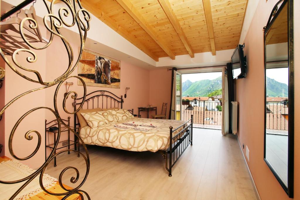 um quarto com uma cama e uma varanda em B&B La Vecchia Tipografia - Lago D'Idro em Ponte Caffaro