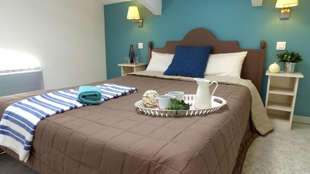 Una cama con una bandeja con toallas y tazas. en VVF Drôme Provence, en Montbrun-les-Bains