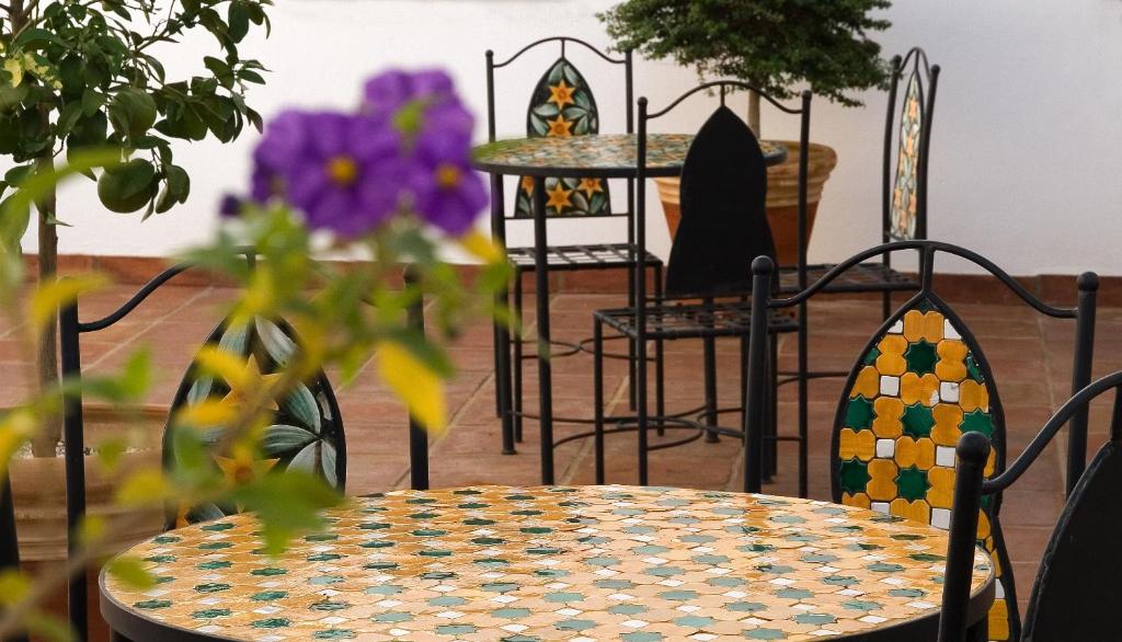 Apartamentos la Fuente في قرطبة: طاولة وكراسي في غرفة بها زهور