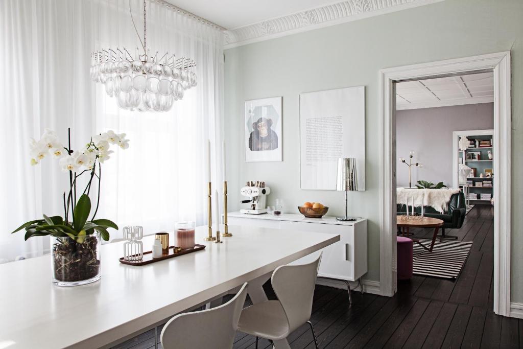 雷克雅維克的住宿－Historic Villa in downtown Reykjavik，白色的厨房配有餐桌和椅子