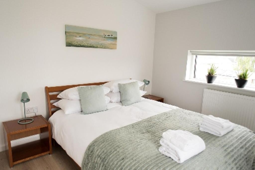 1 dormitorio con 1 cama con sábanas blancas y ventana en Your Space Apartments - Nelson Court en Cambridge