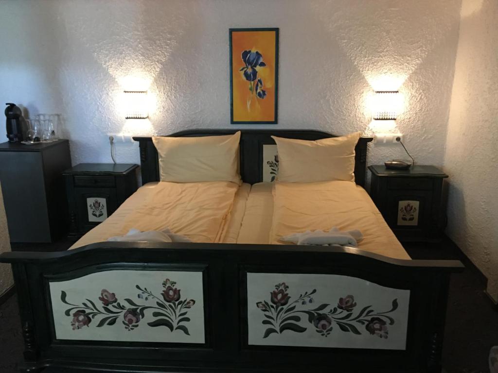 a bedroom with two beds and two lamps on the wall at Hotel Jägerhof in Schluchsee