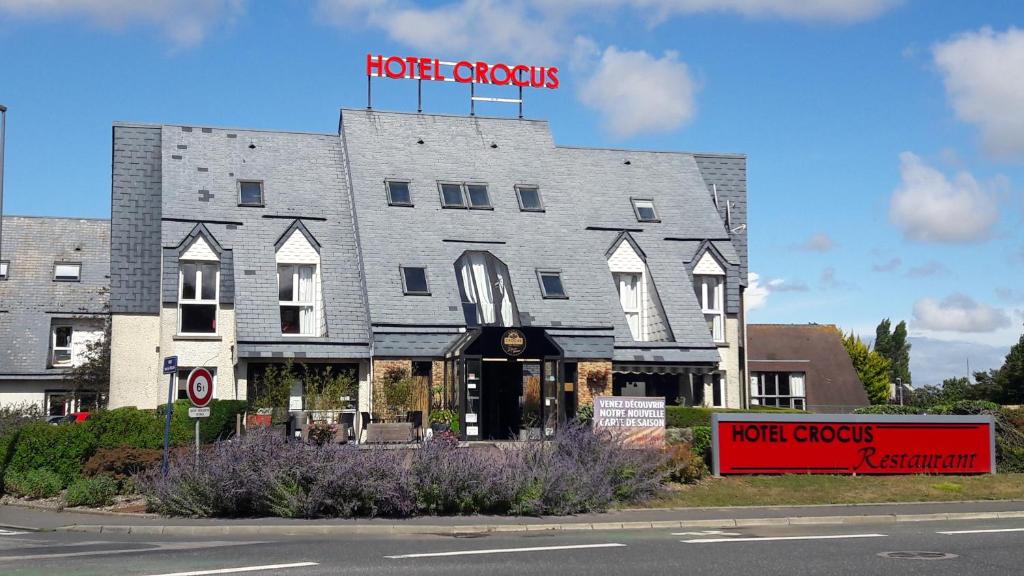 un bâtiment avec un panneau crocus d'hôtel en haut dans l'établissement Hôtel Crocus Caen Mémorial, à Caen