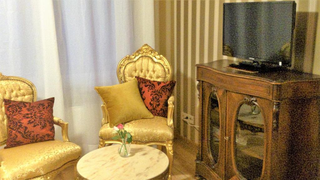 a living room with two chairs and a television at Héritage B&B in Mülheim an der Mosel