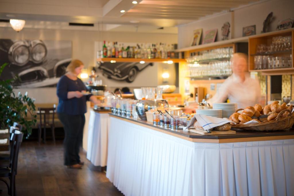 a man and a woman standing at a counter in a restaurant at Hotel Neufeld in Zürich