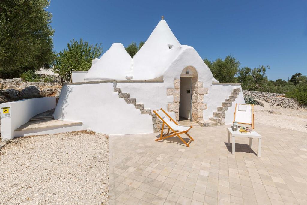 małą białą kaplicę ze stołem i krzesłem w obiekcie Villa Sogno Bianco by BarbarHouse w mieście Ostuni
