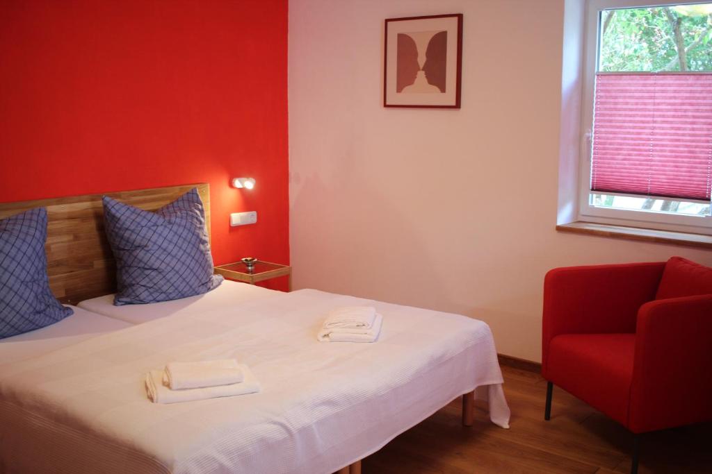 ein rotes Zimmer mit einem Bett und einem roten Stuhl in der Unterkunft Wein und Stein in Randersacker