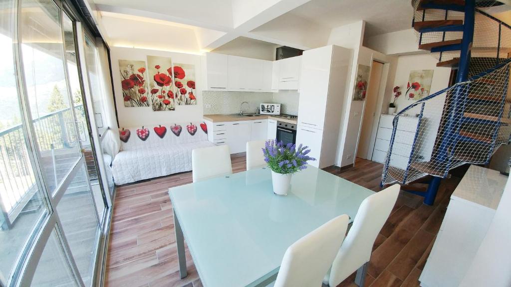 een keuken en een woonkamer met een witte tafel en stoelen bij Apartment Ski Marilleva 1400 in Marilleva