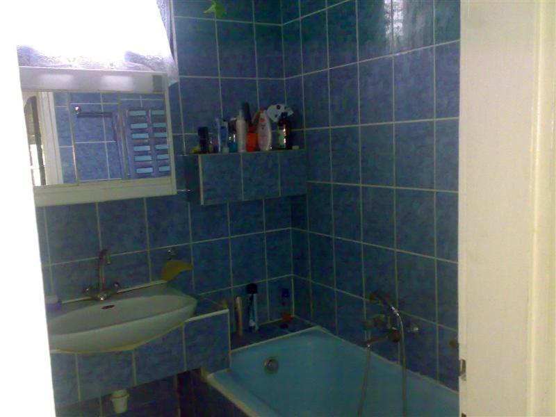 een blauw betegelde badkamer met een wastafel en een bad bij Árnyas Vendégház in Hajdúszoboszló