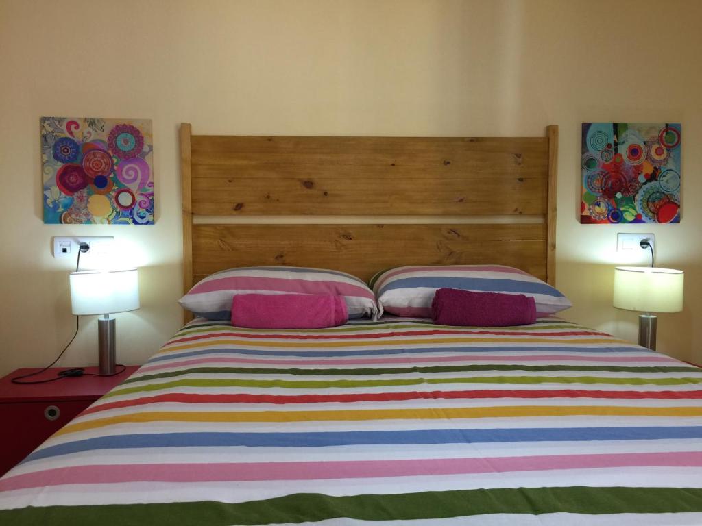 a bedroom with a large bed with two lamps at Apartamento Cuarto Real de Santo Domingo in Granada