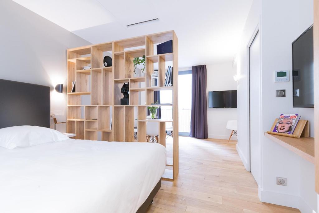 a bedroom with a white bed and wooden shelves at T2 bis luxe hyper centre piscine in Bordeaux