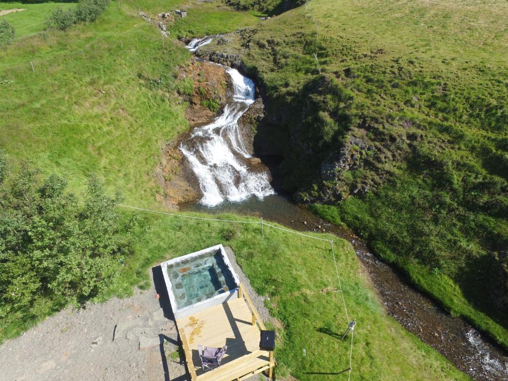 an aerial view of a waterfall next to a house at Stóra-Ásgeirsá Horse Farm Stay in Víðigerði
