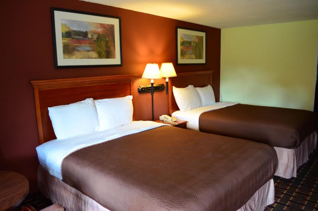 2 camas en una habitación de hotel con 2 lámparas en Greystone Motel, en Hillsboro
