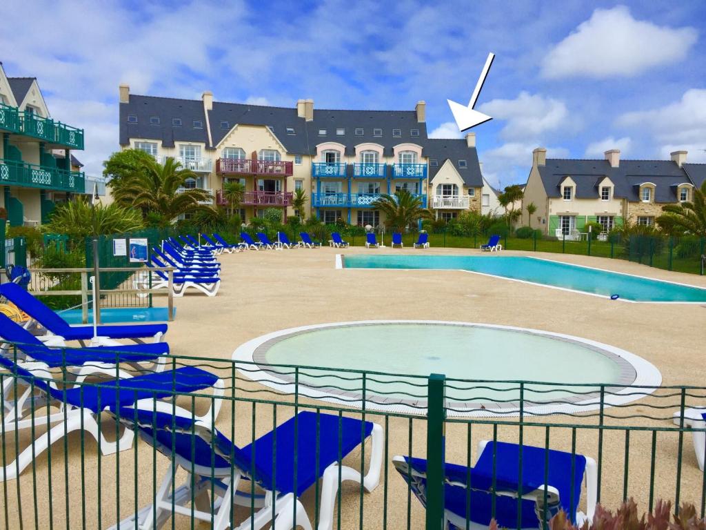 un complejo con sillas y piscina en Residence Cap Marine en Le Guilvinec