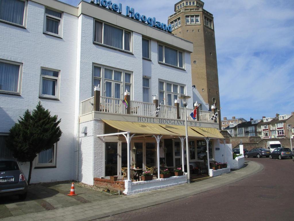 a hotel with a balcony with people standing on it at Hotel Hoogland Zandvoort aan Zee in Zandvoort