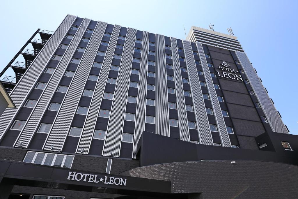 un edificio de hotel alto con un cartel en Hotel Leon Hamamatsu, en Hamamatsu