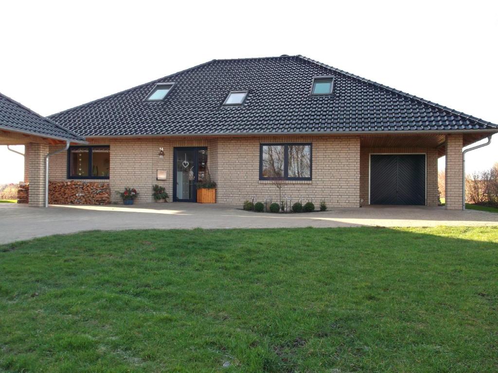 a brick house with a garage and a grass yard at Ferienwohnung Kranichzug in Kargow