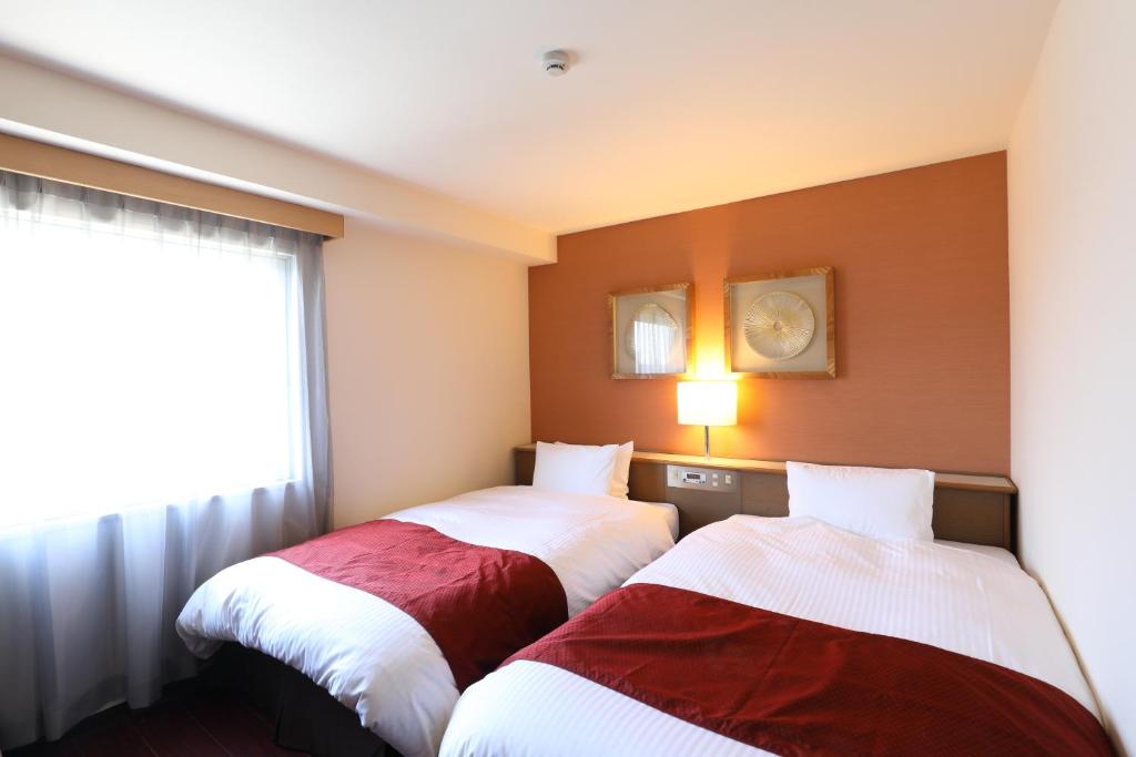 Postel nebo postele na pokoji v ubytování Hotel Leon Hamamatsu
