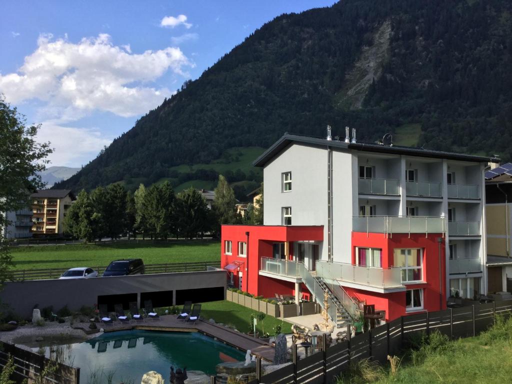 een gebouw met een zwembad voor een berg bij Alpine Appart in Bad Hofgastein