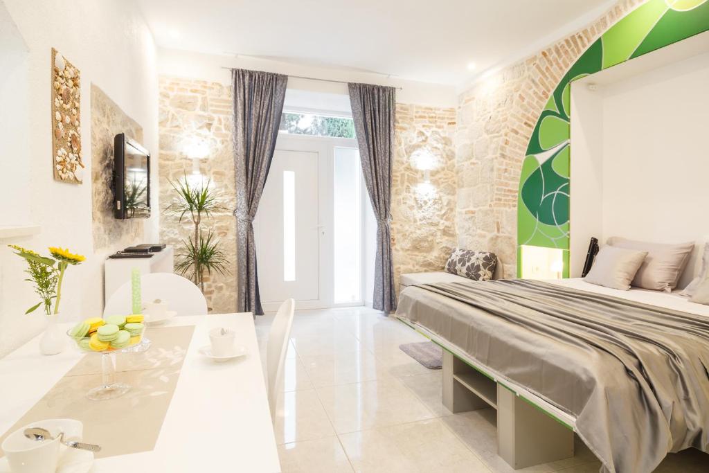 a bedroom with a large bed and a table at Apartment Maleš in Split