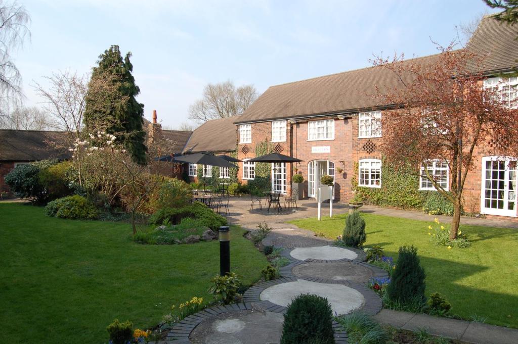 a house with a walkway in front of a yard at Marston Farm Hotel in Sutton Coldfield