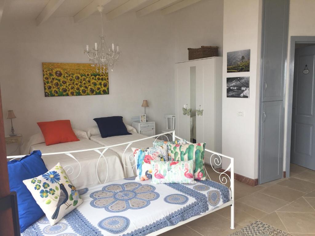 a bedroom with a white bed with colorful pillows at El Laurel in Frontera