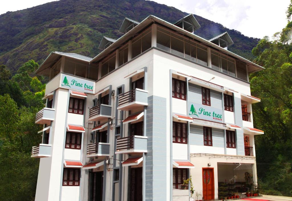 a hotel in front of a mountain at Pine Tree Munnar in Munnar
