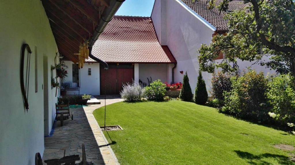 ein kleiner Hof mit grünem Rasen neben einem Haus in der Unterkunft Slovácká chalupa in Strážnice
