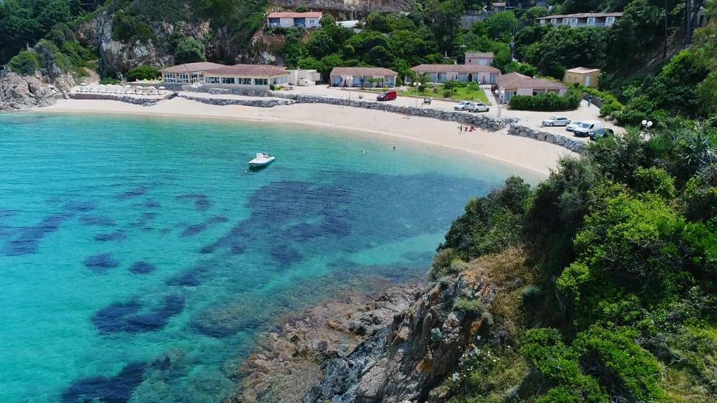 uma vista aérea de uma praia com um barco na água em Hôtel Sampiero Corso em Propriano