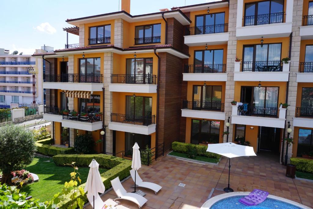 un immeuble d'appartements avec un patio et une cour dans l'établissement Boulevard Sea Residence, à Sunny Beach