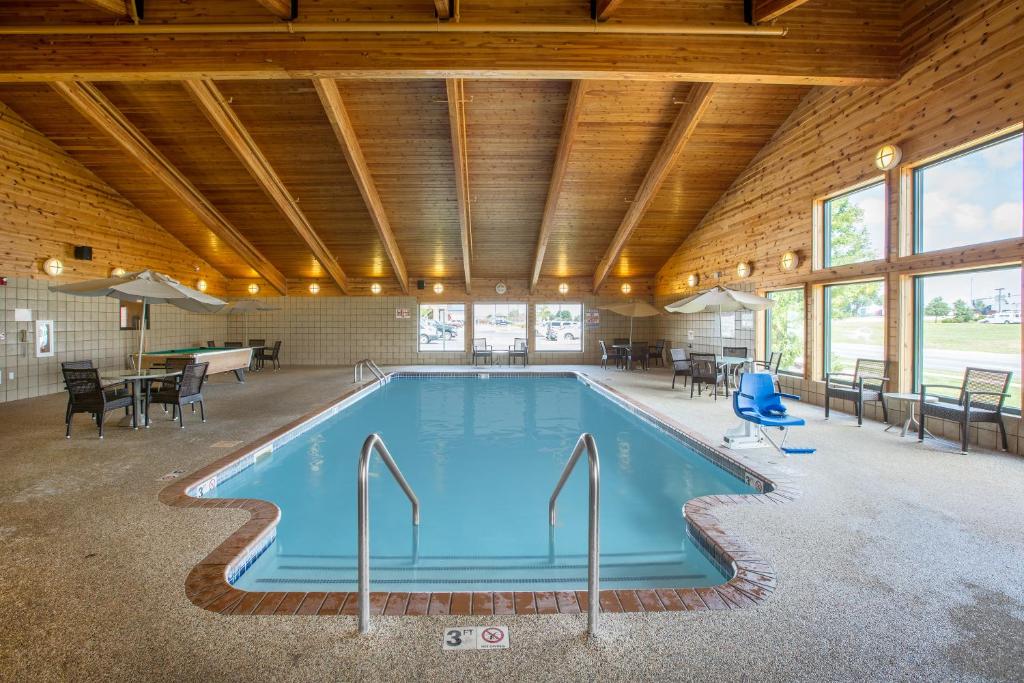 uma piscina num edifício com tecto de madeira em AmericInn by Wyndham Lincoln South em Lincoln