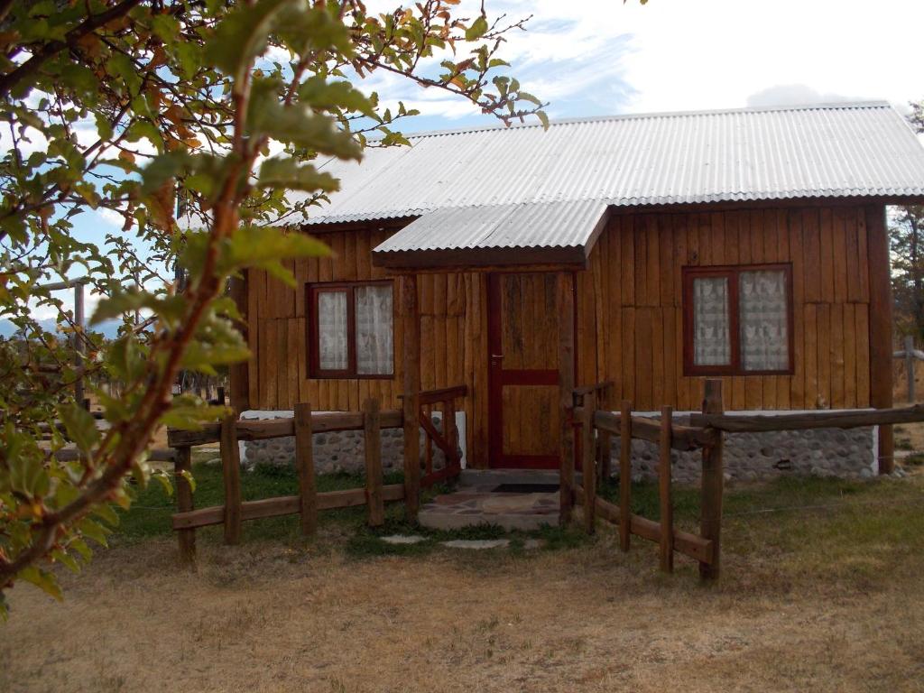 a wooden cabin with a fence in front of it at Posada Tajaluz in Río Pico