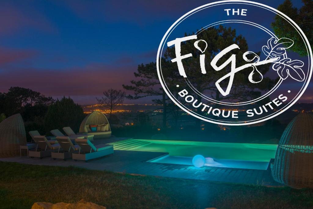 a sign for the fire luxurious suites at night at The Fig Boutique Suites in Salir do Porto