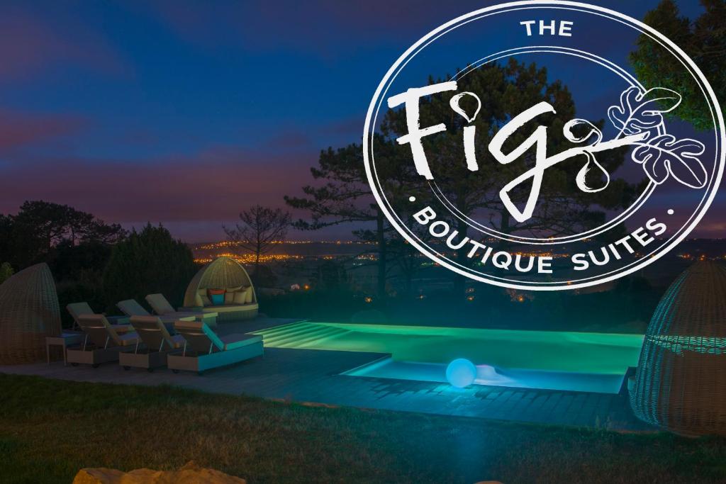 - un panneau indiquant les suites luxueuses avec cheminée la nuit dans l'établissement The Fig Boutique Suites, à Salir de Porto