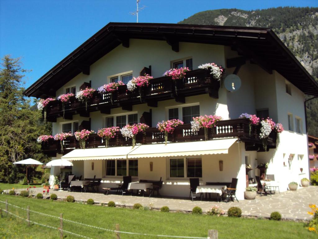 a large white building with flowers on the balconies at Bergheim in Pertisau