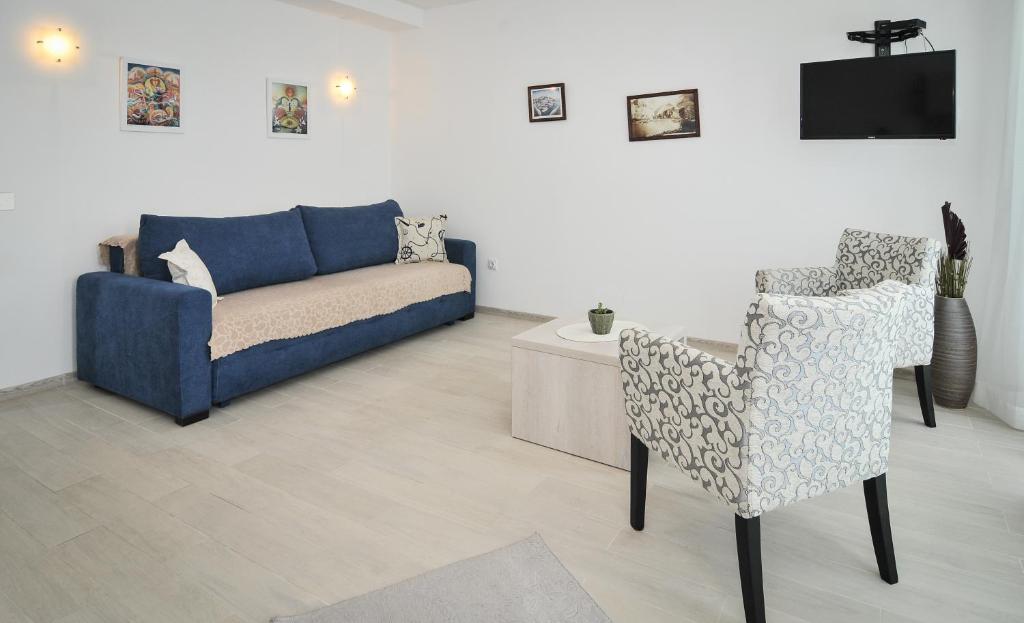 ein Wohnzimmer mit einer Couch und einem Sessel in der Unterkunft Apartments Zukovac in Tivat