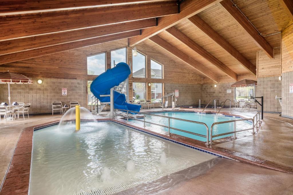 - une piscine intérieure avec toboggan dans un bâtiment dans l'établissement AmericInn by Wyndham Fargo West Acres, à Fargo
