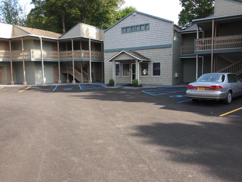 a car parked in a parking lot in front of a building at Town House Inn in Oneonta