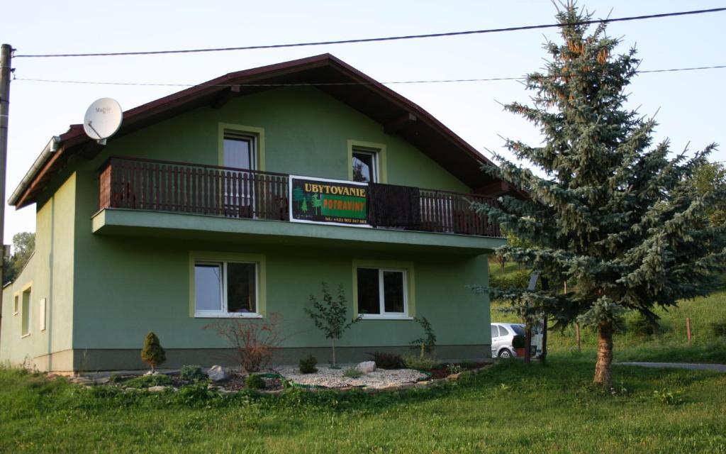 una casa verde con balcón en la parte superior. en Dolinka Holiday Home, en Levoča