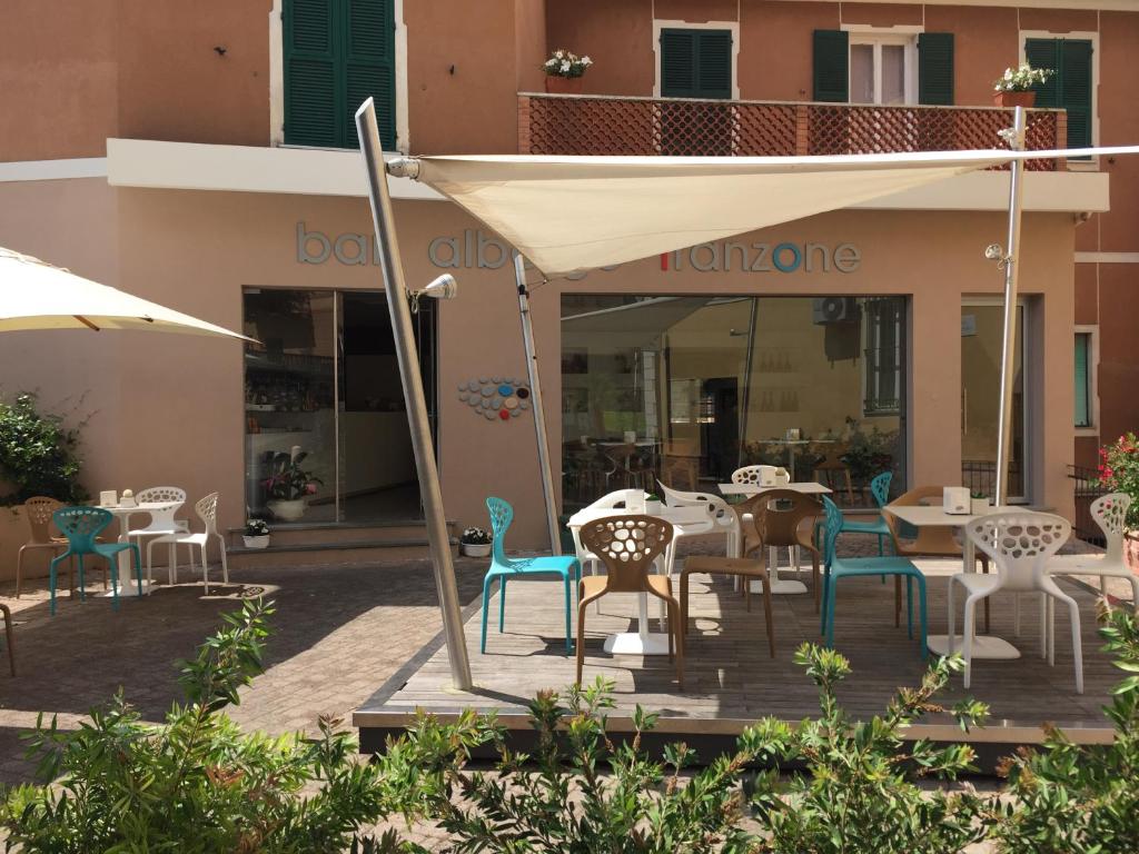 a patio with tables and chairs in front of a building at Albergo Franzone in Tovo San Giacomo