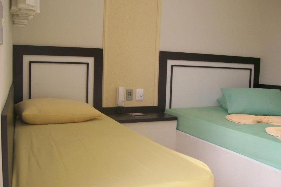 1 dormitorio con 2 camas de color amarillo y verde en Hotel Pousada Village en Sorocaba