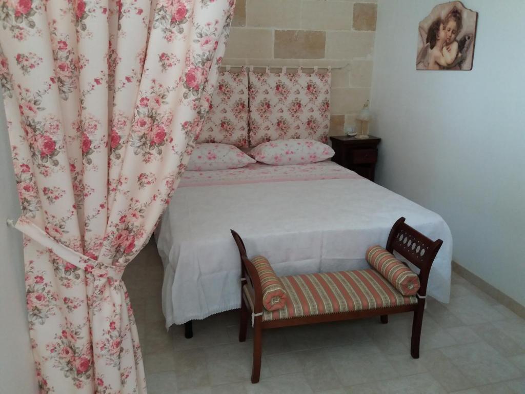 マンドゥーリアにあるL'Antica Casa Di Cosmaritaのベッドルーム1室(カーテン付きのベッド1台、椅子付)